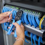 Two hands installing network cabling by CKC Data Solutions