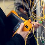 Technician installing fiber optic cables in a building
